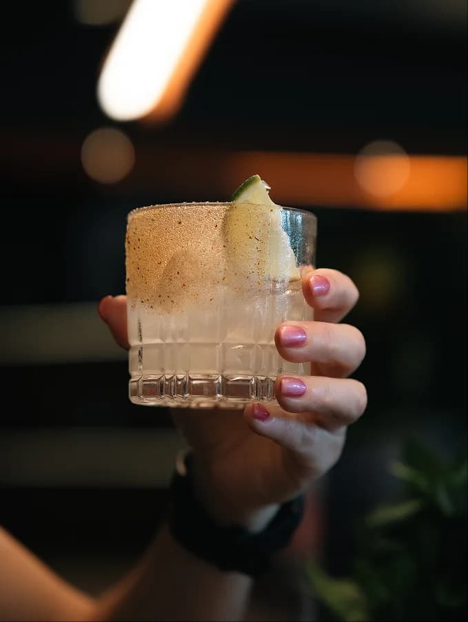 Two cocktails on a warm-toned surface at Many Little bar