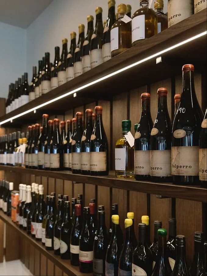 Wine bottles on shelves in the Many Little larder